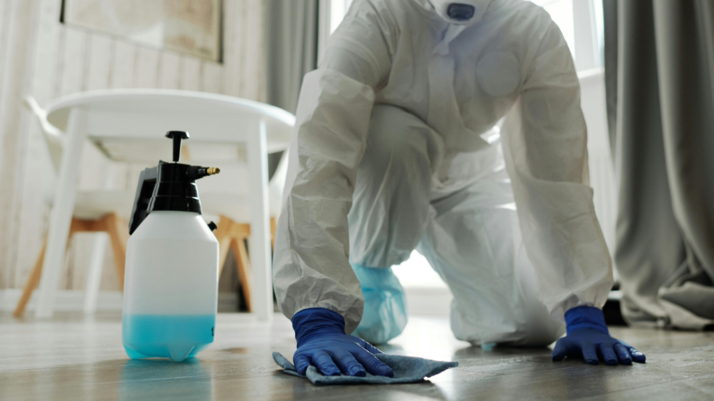 Professional disinfection technician wearing PPE with yellow gloves and cleaning equipment in Singapore